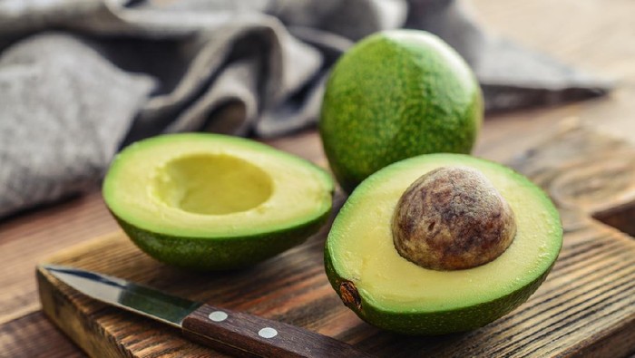 Ilustrasi pria memetik alpukat dari pohon di Jakarta Selatan